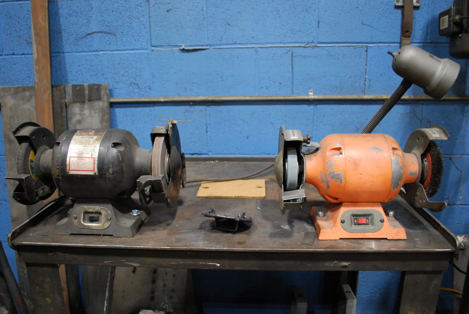 Orange and black bench grinders on workbench