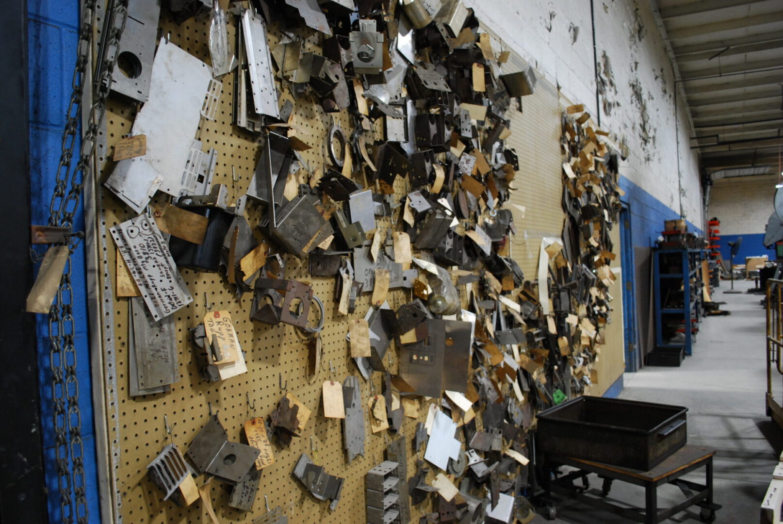 Workshop pegboard wall hung with metal parts