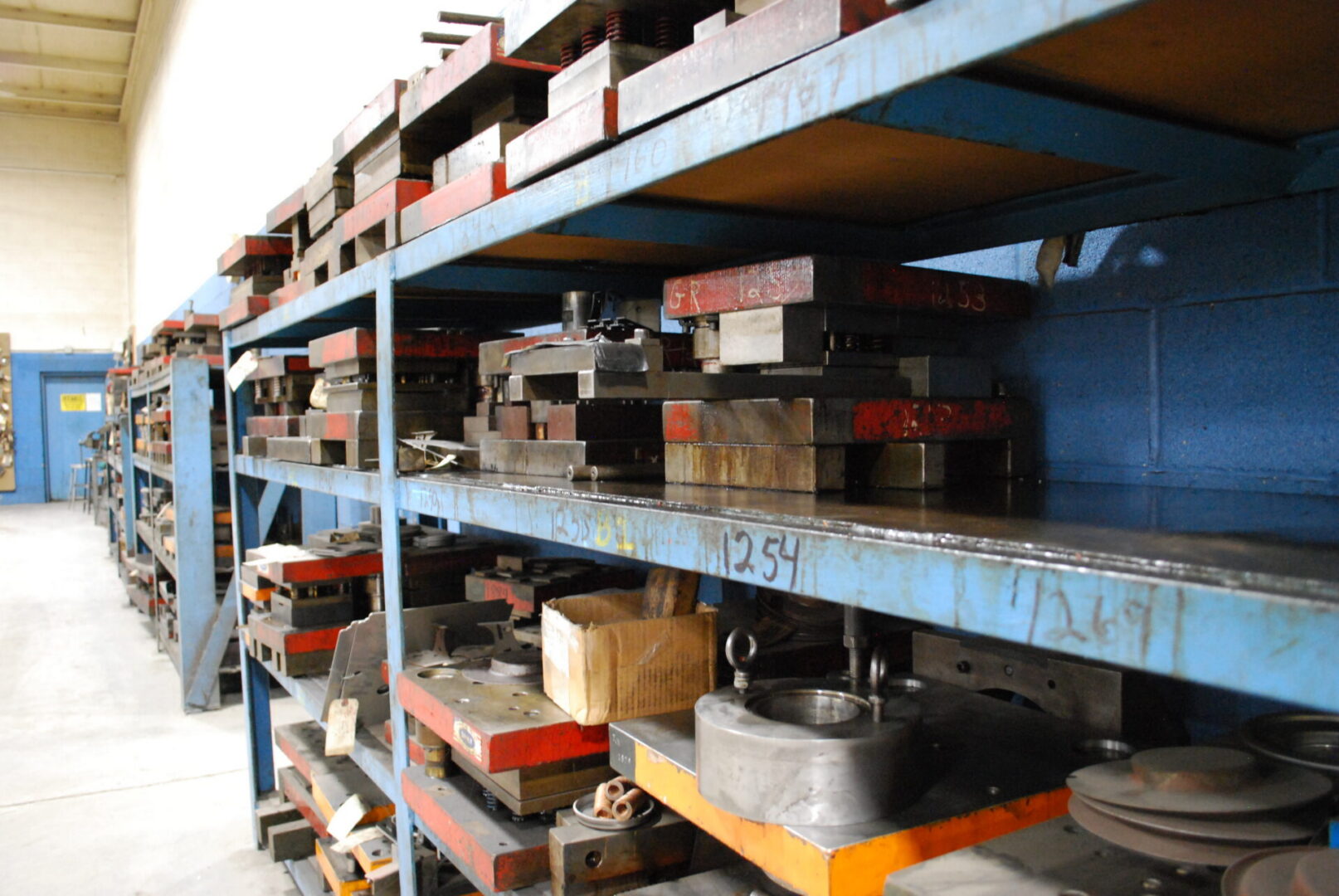 Industrial metal molds and dies on shelving