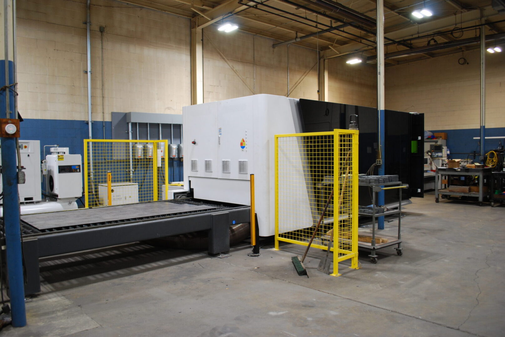 Industrial CNC laser cutting machine with safety fencing